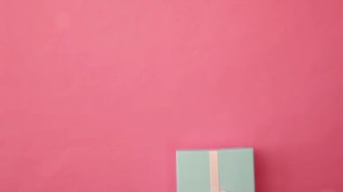 Pembe renkli arka planda izole edilmiş mavi hediye kutusunu tutan kadın eli tasarımı. Noel yeni yıl sevgililer günü kutlaması. Romantik bir hediye. Boşluğu kopyala