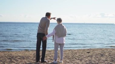 Yaşlı bir çift kumsalda yürüyüş yaparken kucaklaşıp eğleniyorlar. Yaşlı karı şefkatle kucaklaşıyor aşk tatlı bir bağın tadını çıkarıyor. Büyükannem ve büyükbabam birlikte. Aile anı aşkı