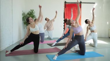 Yoga sınıfı pilates egzersizi. Bir grup sporcu, yoga sağIık meditasyonu için stüdyo sınıfında egzersiz yapıyor. Spor salonunda yoga yapan erkek antrenörler. Spor salonunda esneme hareketleri yapan kadınlar.