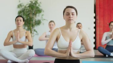 Yoga farkındalığı meditasyonu. Yoga sağlık farkındalığı meditasyonu için stüdyoda egzersiz yapan bir grup sporcu. Nilüfer çiçeğinde oturup yoga yapan erkek kadınlar meditasyon yapıyor.