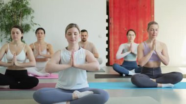 Yoga farkındalığı meditasyonu. Yoga sağlık farkındalığı meditasyonu için stüdyoda egzersiz yapan bir grup sporcu. Nilüfer çiçeğinde oturup yoga yapan erkek kadınlar meditasyon yapıyor.