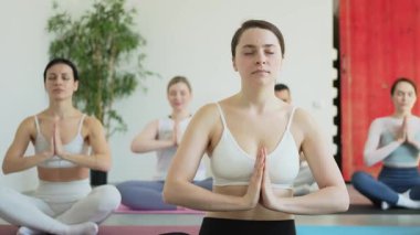 Yoga farkındalığı meditasyonu. Yoga sağlık farkındalığı meditasyonu için stüdyoda egzersiz yapan bir grup sporcu. Nilüfer çiçeğinde oturup yoga yapan erkek kadınlar meditasyon yapıyor.