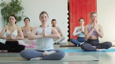 Yoga farkındalığı meditasyonu. Yoga sağlık farkındalığı meditasyonu için stüdyoda egzersiz yapan bir grup sporcu. Nilüfer çiçeğinde oturup yoga yapan erkek kadınlar meditasyon yapıyor.