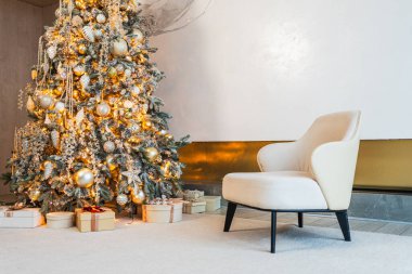 Klasik Noel dekore edilmiş oturma odası. Modern klasik iç tasarım dairesi rahat koltuğu ve beyaz altın süslemeli Noel ağacı. Evde Noel arifesi