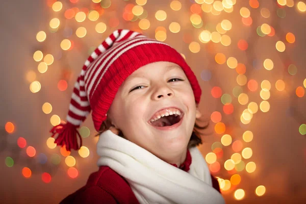 クリスマス帽子 カラフルな背景で笑う少年 ストック写真