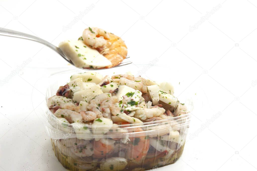 sea salad topped in transparent tub with shrimp