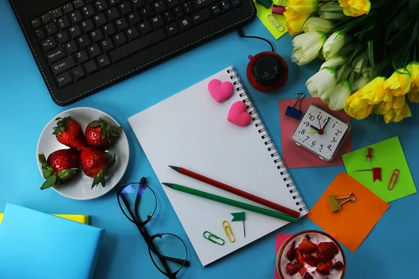 office work place. Strawberry. yogurt. notepad and stationery. color background.