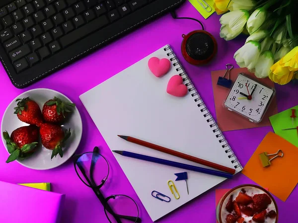 office work place. Strawberry. yogurt. notepad and stationery. color background.