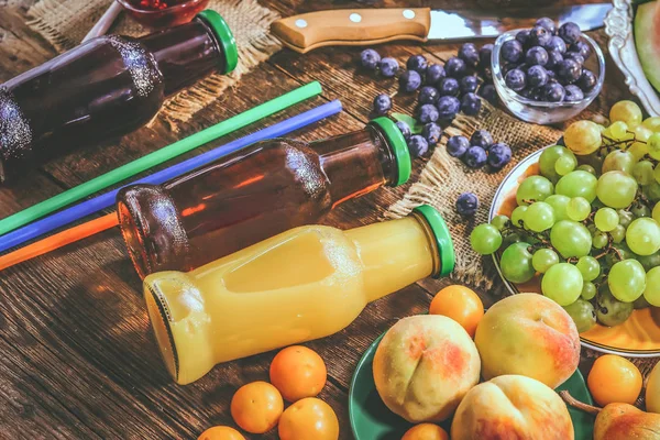 bottles with fruit juice. summer and autumn fruits.