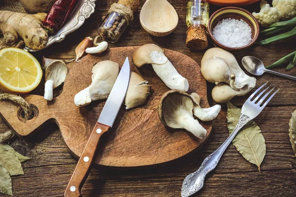cooking mushrooms, spices, ingredients, vegetables, cooking utensils. wooden background.