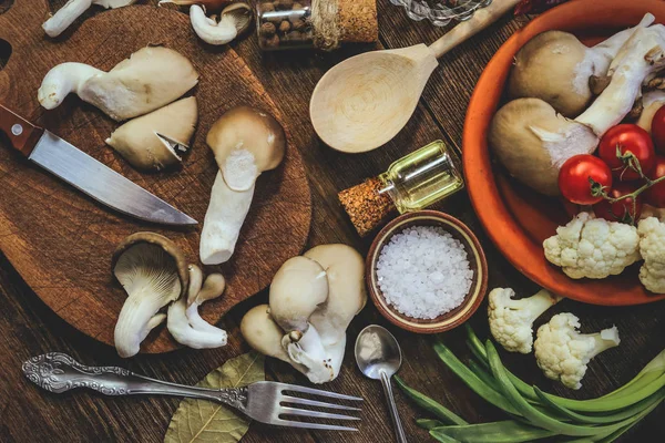 cooking mushrooms, spices, ingredients, vegetables, cooking utensils. wooden background.