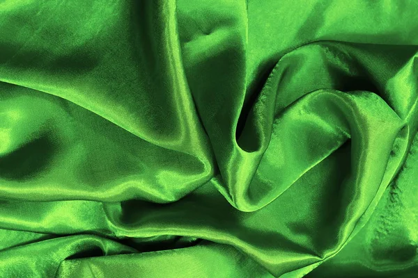 smooth folds of green satin fabric. silk. Satin background. toned