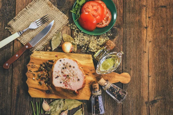 ham with spices and oils on a wooden background