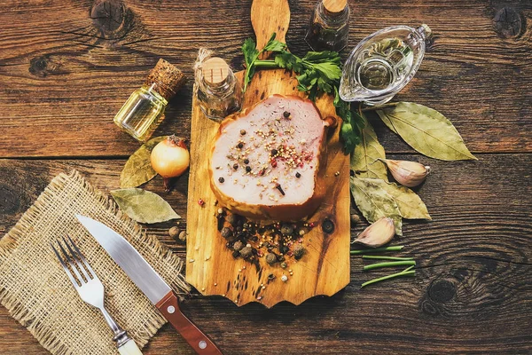 ham with spices and oils on a wooden background