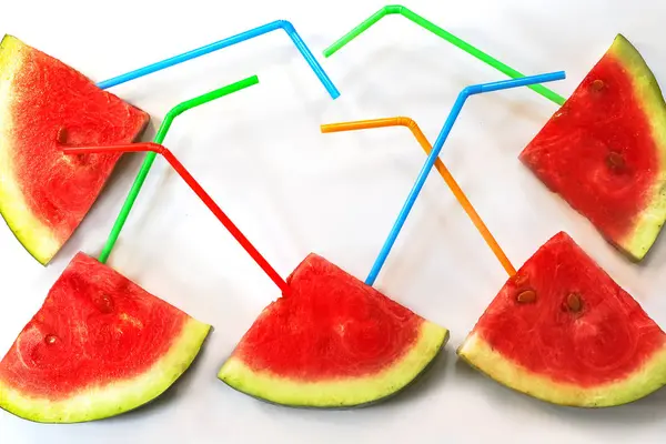 slices of watermelon with straws for juice. On a white background.
