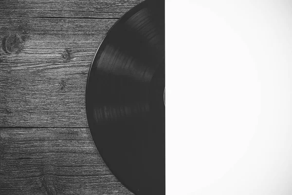 black vinyl record in an envelope. on a wooden board.