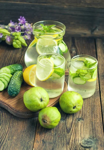 Detox water in a pitcher and glasses with cucumbers. A healthy drink.