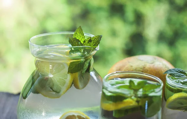 Pitcher with detox water with cucumber, lemon and mint leaves.