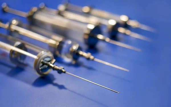 Vintage medical syringes. Selective focus. blue background.