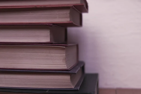 stack of books on toned wall background