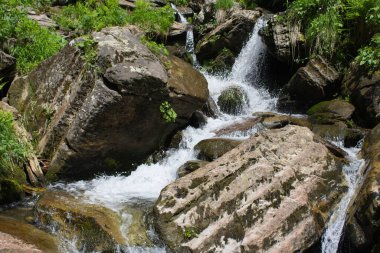 Dağ kaynayan bir su akıntısı kayaların üzerinden akıyor.