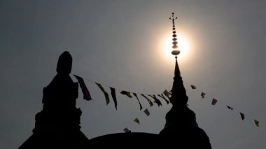 Budist stupa siluet ve uçan dua bayrakları, ve geri pagoda düşüyor güneşin Tayland winter.a yerlerde.