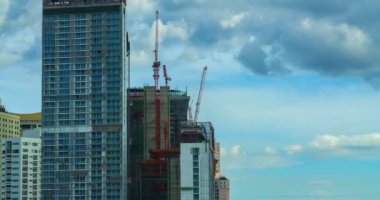 Bir binanın altında yüzen bulutlar ile inşaat çalışmalarına hızlı vinç 