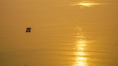 Akşam günbatımı sessiz geniş denizde küçük yerel balıkçı tekneleri.