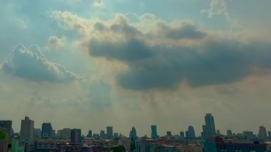 Stratocumulus bulutları bir katman oluşturur ve Tayland 'ın Bangkok kentindeki yerleşim yerlerindeki binaların üzerinden hızla geçer..