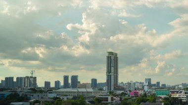 Stratocumulus bulutları bir katman oluşturur ve Tayland 'ın Bangkok kentindeki yerleşim yerlerindeki binaların üzerinden hızla geçer..