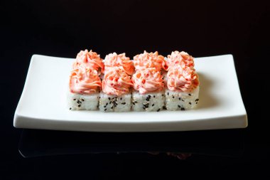 Siyah bir arka plan üzerinde geleneksel taze Japon set suşi rulo