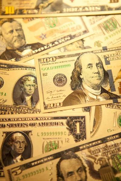 Munt ons gouden dollar biljetten close-up achtergrond. — Stockfoto