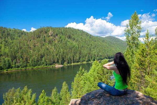 Jovem mulher viajante sentada no topo do penhasco da montanha . — Fotografia de Stock