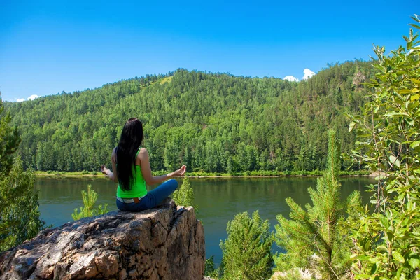 Giovane donna in viaggio seduta sulla cima della scogliera di montagna . — Foto Stock