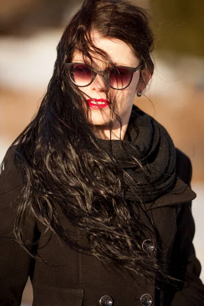 Giovane donna in posa in cappotto nero e cappello nero . — Foto Stock