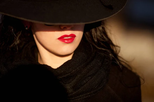 Jeune femme posant en manteau noir et chapeau noir . — Photo