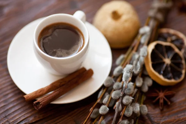 Tazza di caffè e rami di salice, limone secco, cannella . — Foto Stock