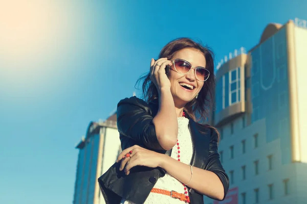 Aantrekkelijke zakenvrouw met een mobiele telefoon in de stad in de dag van sanny. — Stockfoto