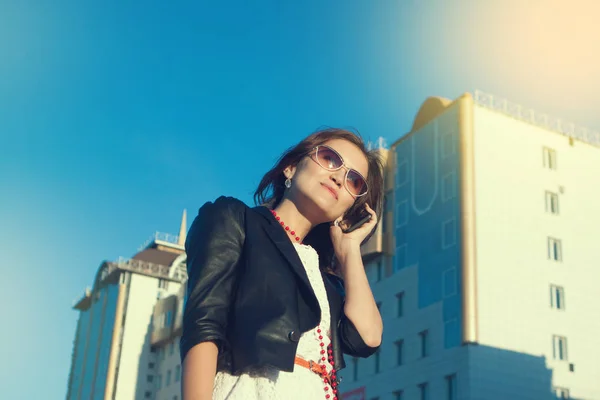 Aantrekkelijke zakenvrouw met een mobiele telefoon in de stad in de dag van sanny. — Stockfoto