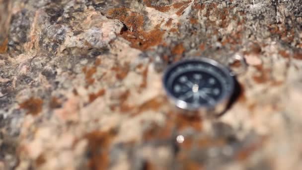 Brújula magnética con esfera negra sobre una piedra salvaje cubierta de musgo . — Vídeo de stock