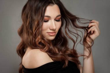 Uzun kahverengi kıvırcık saçlı güzel bir kadın..