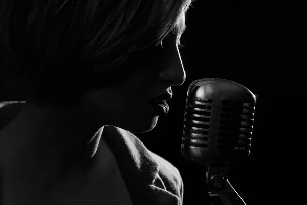 Silhouette of singing woman with retro microphone