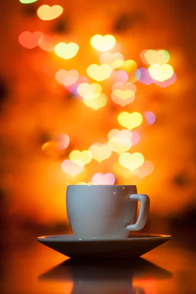 Xícara de chá no fundo bokeh na forma de corações — Fotografia de Stock