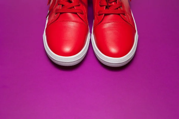 Красные кроссовки на фиолетовом фоне — стоковое фото