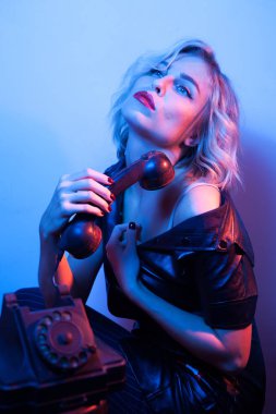 Neon gece ışıkları telefon ile moda giyim giyinmiş çekici kadın.