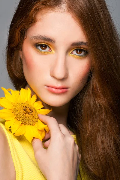 Donna con trucco colorato elegante e girasoli — Foto Stock