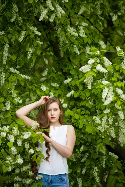 Portrét ženy na pozadí kvetoucího ptáka třešně. — Stock fotografie