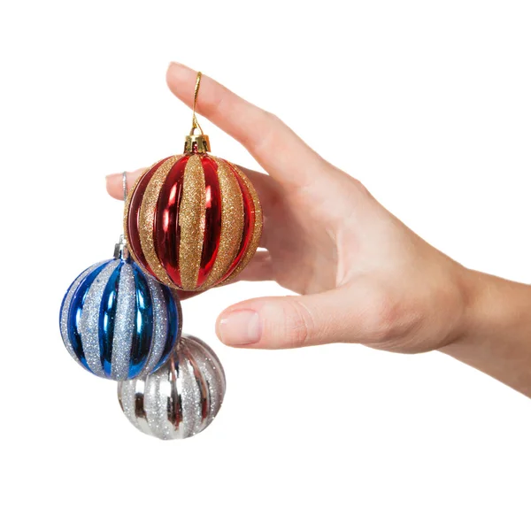 Mano sosteniendo tres bolas de árbol de Navidad de diferentes colores — Foto de Stock