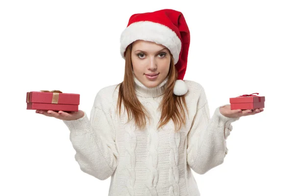 Frau trägt Weihnachtsmütze und weißen Strickpullover mit zwei Geschenken in ihren Händen isoliert weißen Hintergrund — Stockfoto