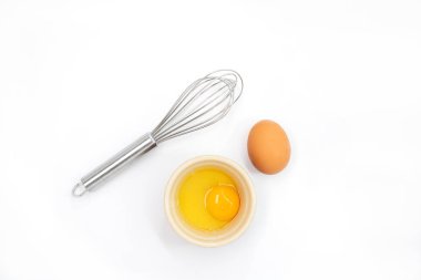 Beyaz bir arka plan üzerinde bir yumurta, yumurta sarısı ve çırpma üst görünümü